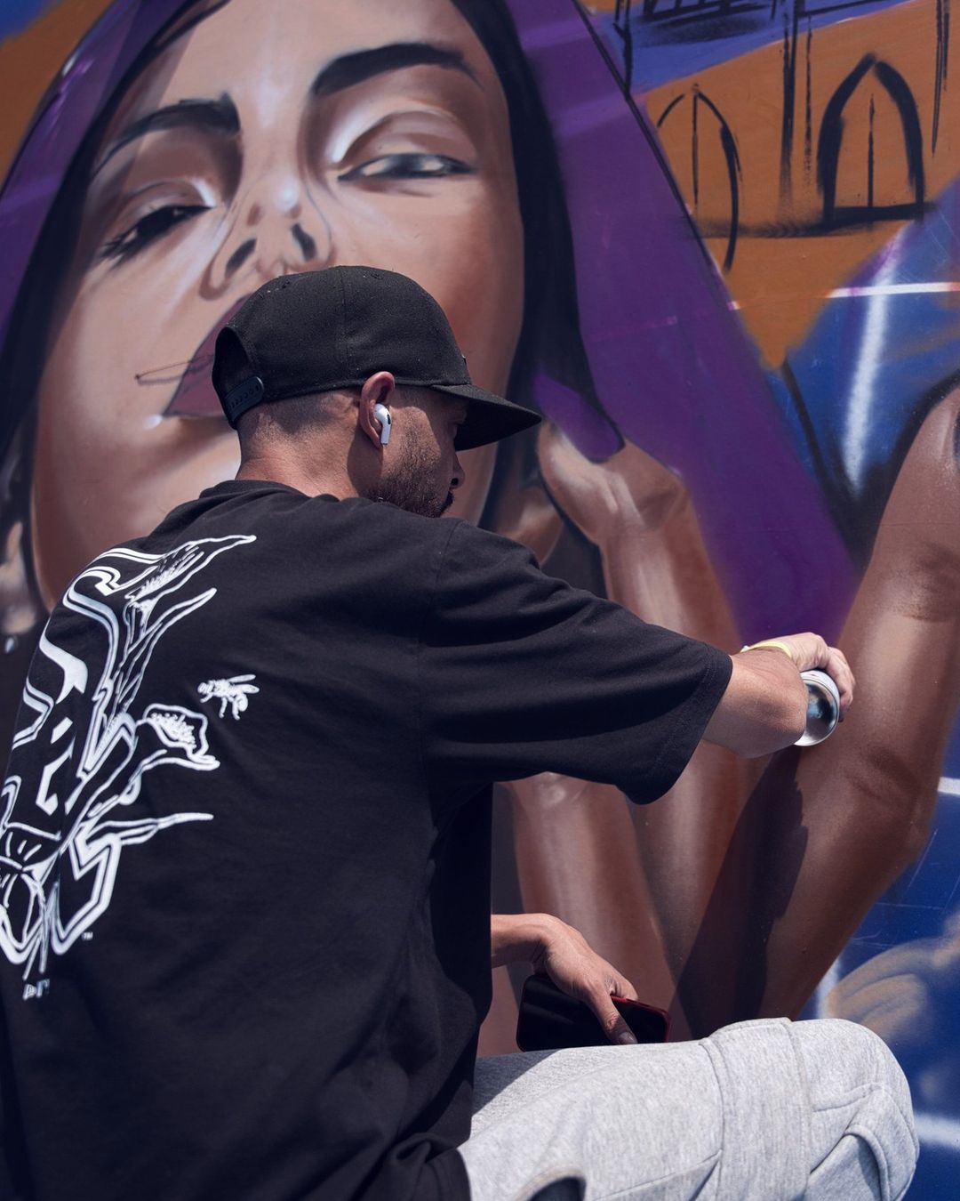 Un graffeur peint une fresque de visage de femme, en 2026
